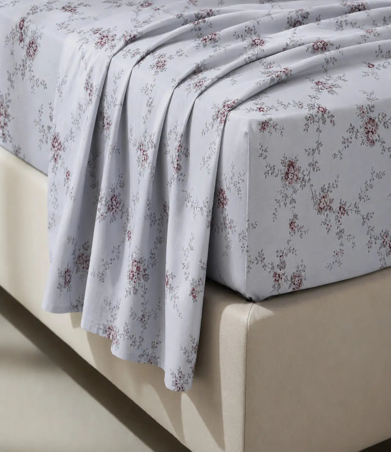 Close-up of an ivory 100% cotton bedsheet highlighting delicate dusty rose floral vine print, soft cotton texture, elegant drape, and premium fabric finish.
