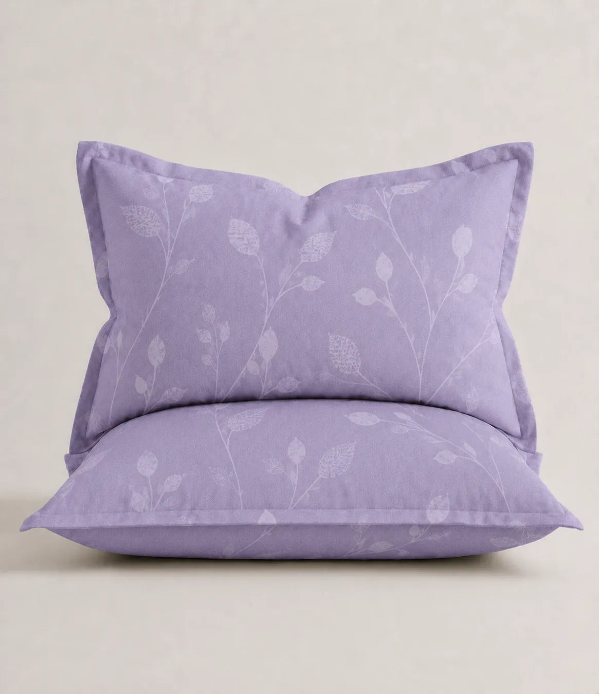 Close-up of a lavender cotton pillow cover featuring a subtle botanical vine print with coordinated matching bedding.