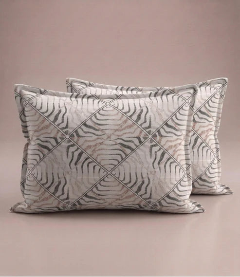 Matching 100% pure cotton pillow covers featuring an elegant ivory, taupe, and grey abstract geometric stripe pattern for a modern bedroom.