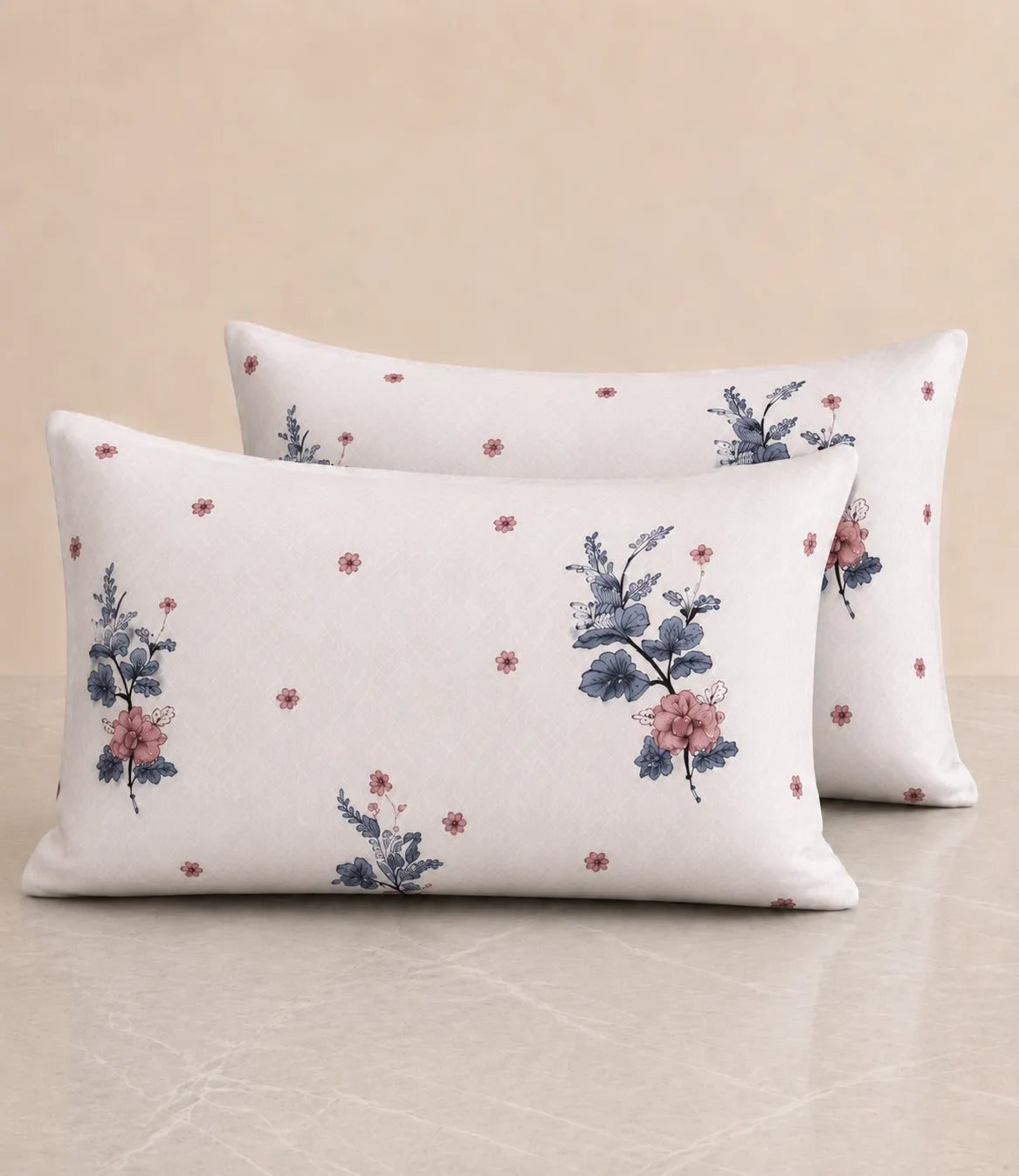 Set of two white cotton pillow covers with elegant blue and pink floral print and delicate scattered floral accents.