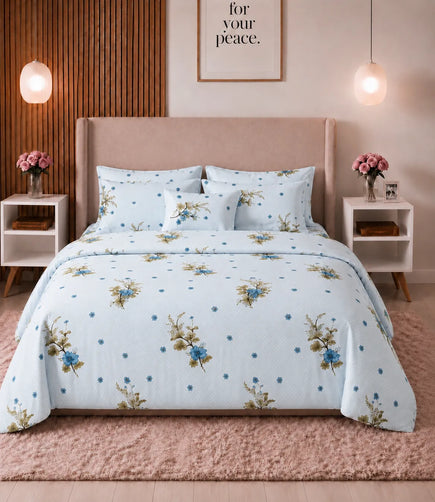 Light blue queen-size cotton bedsheet with elegant blue floral bouquets and delicate dotted accents, neatly spread on a bed with matching pillow covers in a warm, modern bedroom setting.
