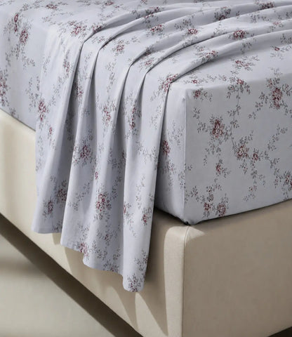 Close-up of an ivory 100% cotton bedsheet highlighting delicate dusty rose floral vine print, soft cotton texture, elegant drape, and premium fabric finish.