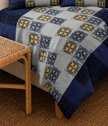 Close-up of a premium 100% cotton royal blue and grey bedsheet featuring ethnic geometric motifs with soft breathable fabric and elegant craftsmanship.