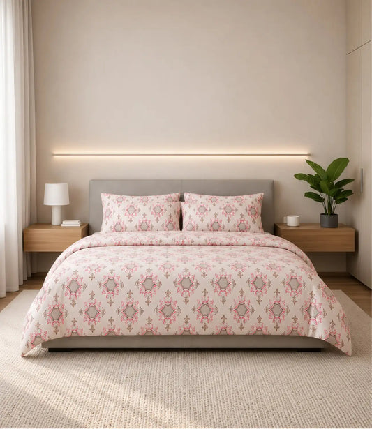 Blush pink king size cotton bedsheet with elegant royal floral motifs and matching pillow covers, styled on a modern upholstered bed in a minimalist luxury bedroom.