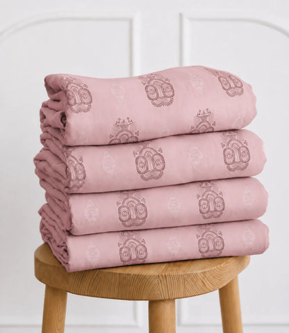 Folded King Size pink printed bedsheet set with traditional ornamental motifs, neatly stacked to highlight the soft fabric and premium finish.