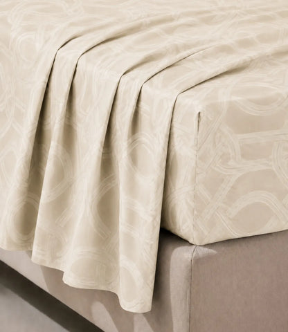 Close-up of a premium 100% pure cotton ivory bedsheet highlighting its elegant interwoven geometric pattern, smooth breathable cotton weave, soft drape, and luxurious finish.