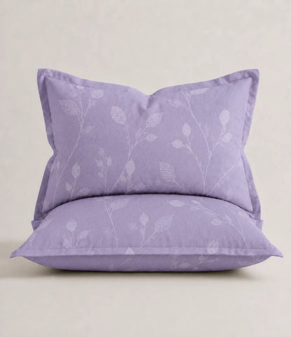 Close-up of a lavender cotton pillow cover featuring a subtle botanical vine print with coordinated matching bedding.