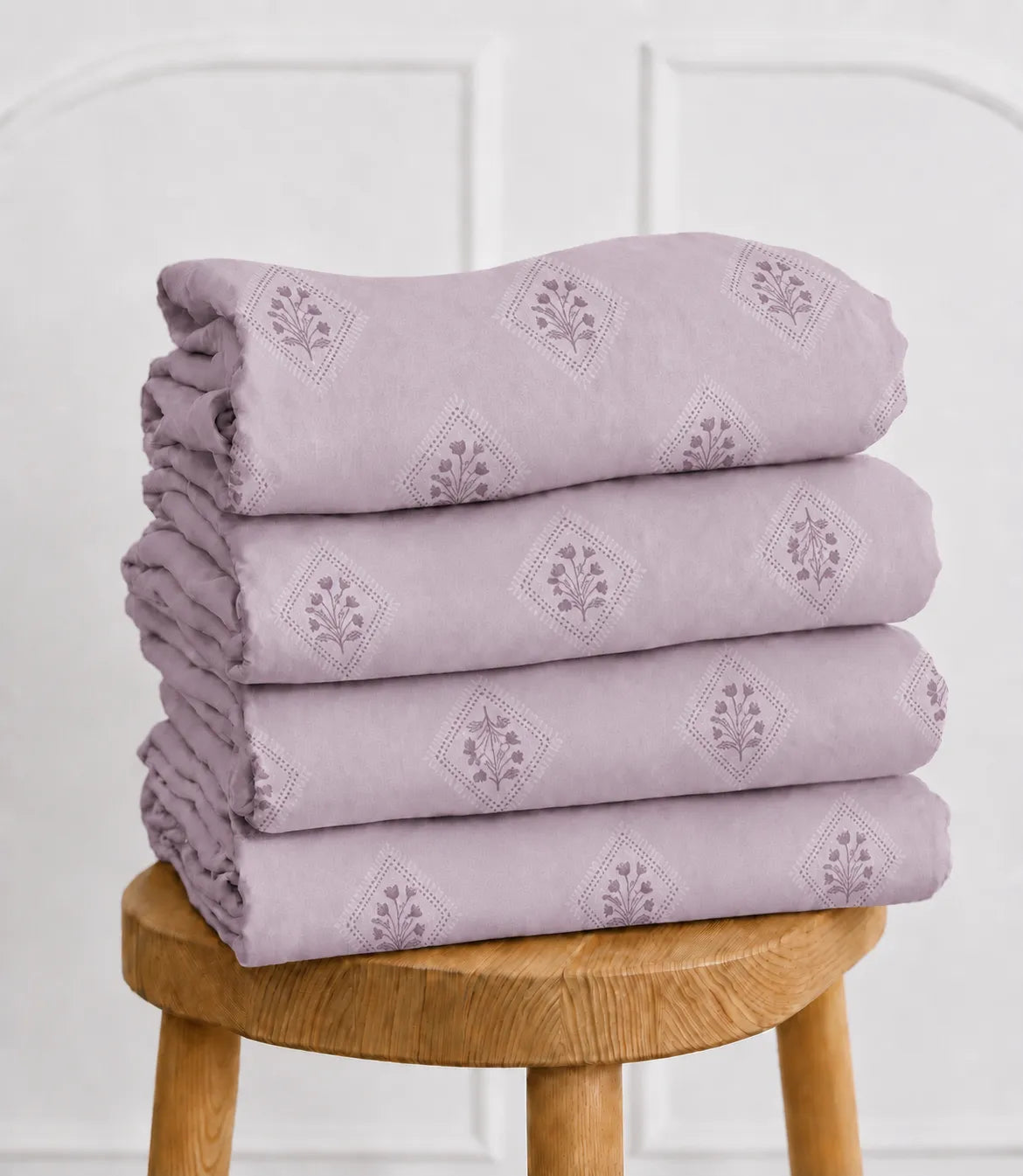 Folded king size lavender cotton bedsheet featuring a delicate floral diamond print. Soft, lightweight fabric provides breathable comfort and easy maintenance for daily use.