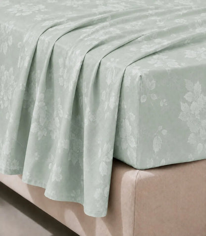 Close-up of king size mint green floral bed sheet highlighting the elegant botanical print, smooth texture, and neatly finished edges.