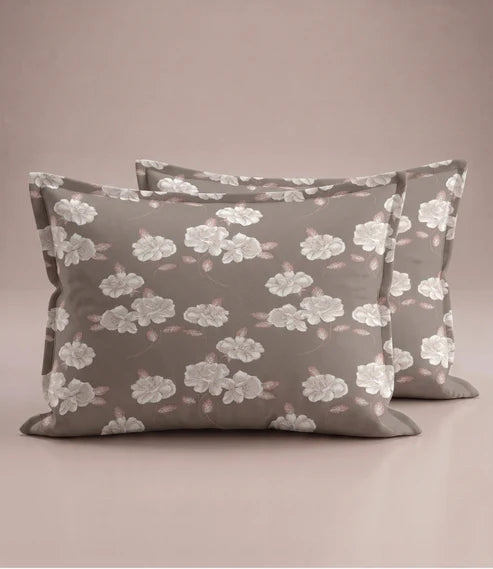 Matching 100% pure cotton pillow covers with elegant white floral prints and soft blush leaves on a warm taupe background, creating a refined and luxurious bedroom aesthetic.