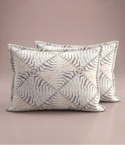 Matching 100% pure cotton pillow covers featuring an elegant beige, taupe, and grey abstract geometric print for a contemporary bedroom.