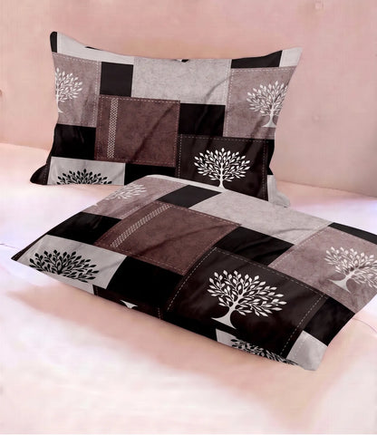 Two matching queen-size cotton pillow covers with a geometric patchwork pattern in mocha brown, beige, and black, accented with white tree prints. Soft, smooth fabric with a contemporary rustic design.