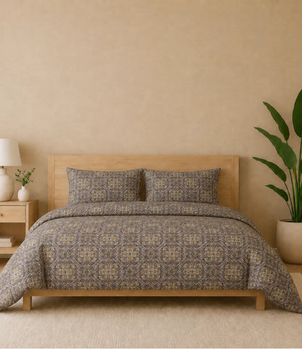 Premium queen size 100% pure cotton bedsheet featuring an elegant taupe geometric mosaic print with intricate heritage-inspired motifs in taupe, brown, beige, and subtle rust accents, styled in a modern wooden bedroom with matching pillow covers for a warm and sophisticated ambience.