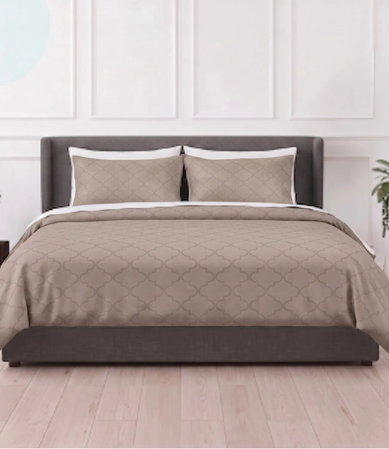 Luxury beige geometric printed bedsheet set neatly spread on a modern upholstered bed, featuring matching pillow covers in a bright contemporary bedroom.