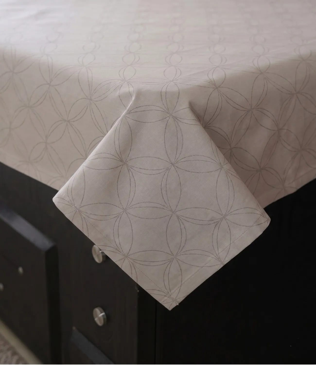Close-up of a premium 100% pure cotton pearl white geometric bedsheet showcasing its smooth drape, breathable weave, fine stitching, and elegant circular pattern.