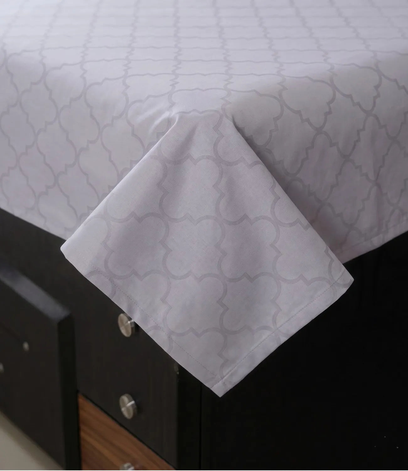 Close-up of silver grey cotton bedsheet showcasing soft fabric, neat stitching, and elegant geometric pattern detail.