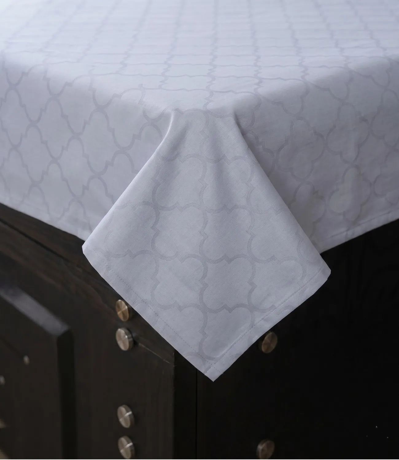Close-up of slate blue cotton bedsheet highlighting soft fabric texture, fine stitching, and elegant geometric design.