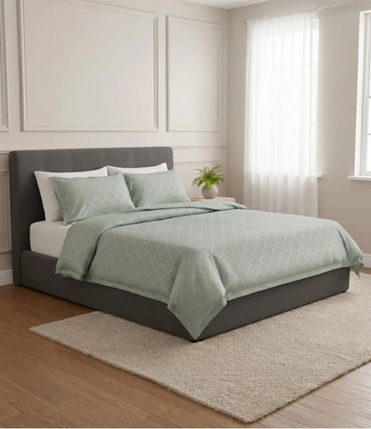 Premium light sage green geometric cotton bedsheet with matching pillowcases styled on a luxury upholstered bed in a contemporary bedroom.