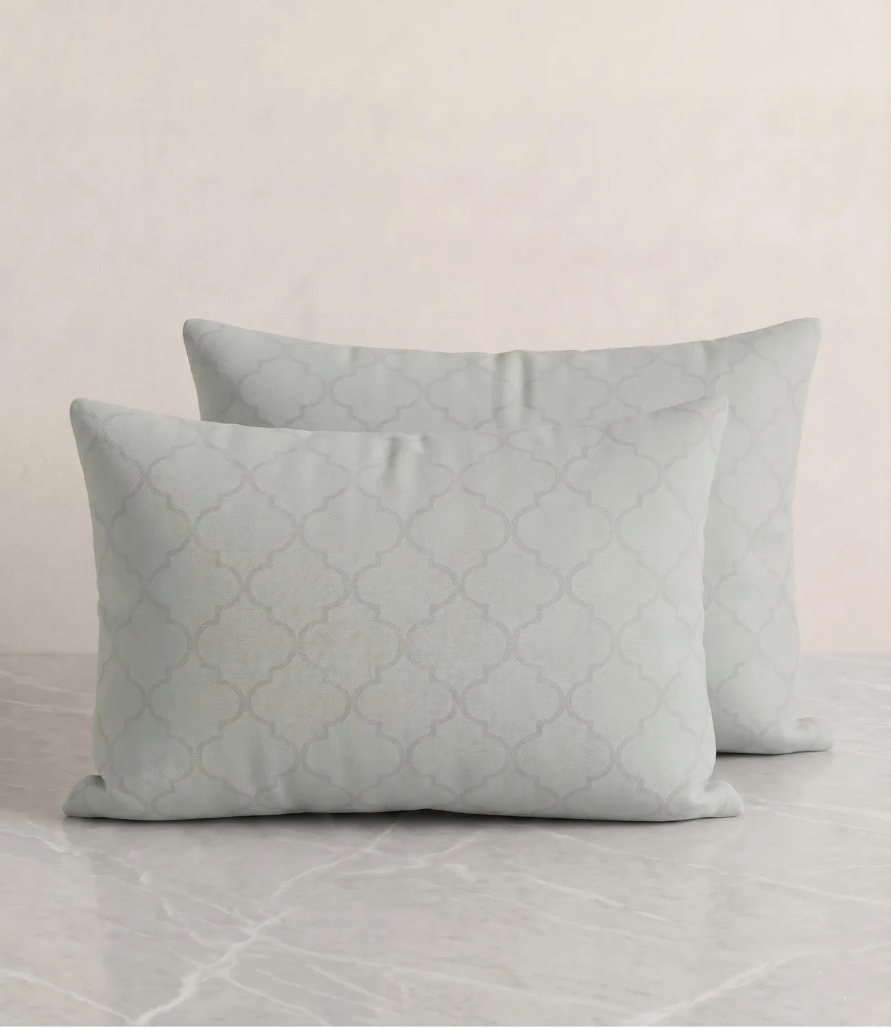 Set of two light sage green cotton pillow covers featuring an elegant geometric quatrefoil pattern and soft breathable fabric.
