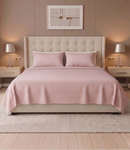 King size Cameo Rose solid cotton bedsheet with two matching pillow covers, neatly styled on a contemporary upholstered bed.