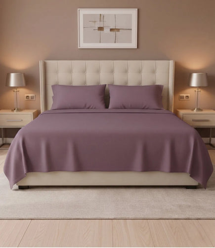 Front view of Soft Heaven plum king size cotton bedsheet with matching pillowcases on a premium upholstered bed in a stylish bedroom.