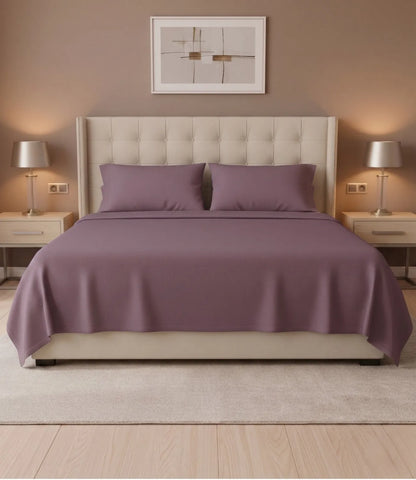 Front view of Soft Heaven plum king size cotton bedsheet with matching pillowcases on a premium upholstered bed in a stylish bedroom.