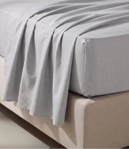 Close-up of Soft Heaven silver grey king size cotton bedsheet showing smooth fabric texture, elegant drape, and fitted mattress corner