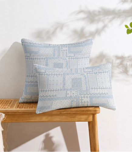 Sky blue patchwork cotton pillow covers featuring vintage-inspired floral and geometric patterns displayed on a wooden console table.