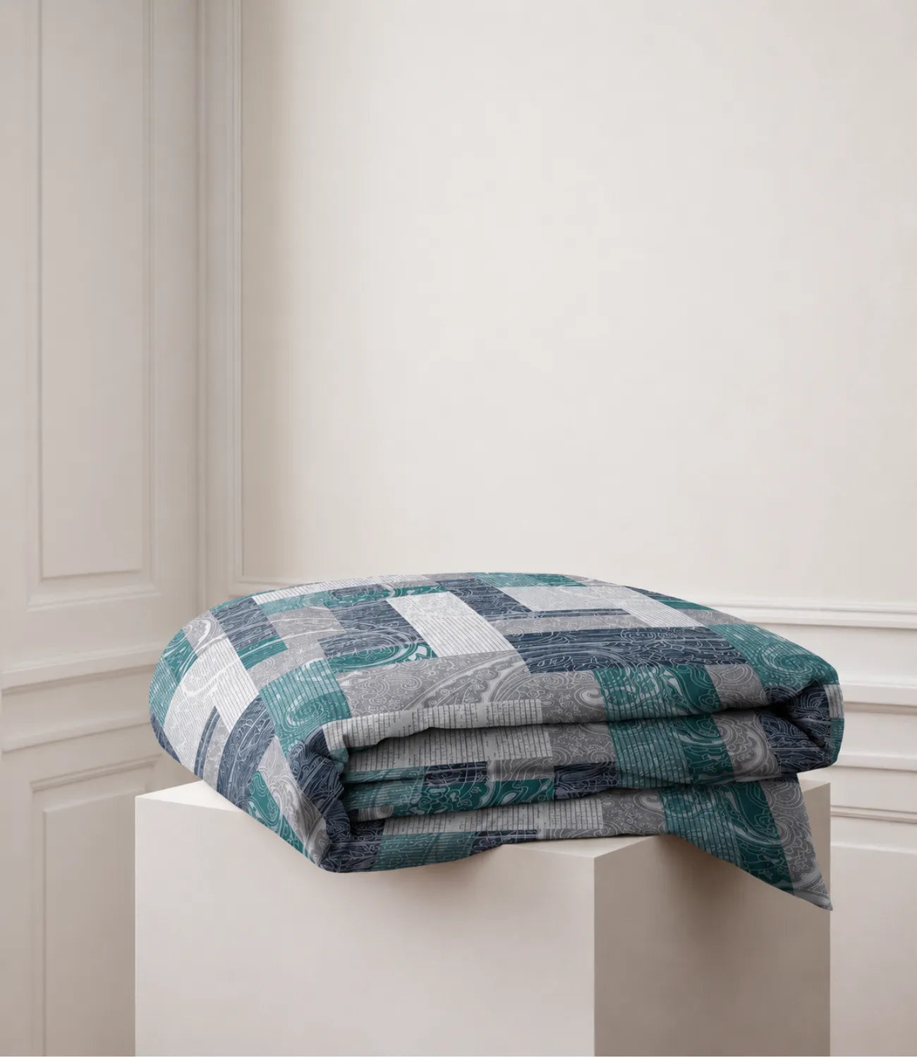 Folded teal geometric patchwork king-size cotton bedsheet showcasing its contemporary printed design and soft cotton fabric.